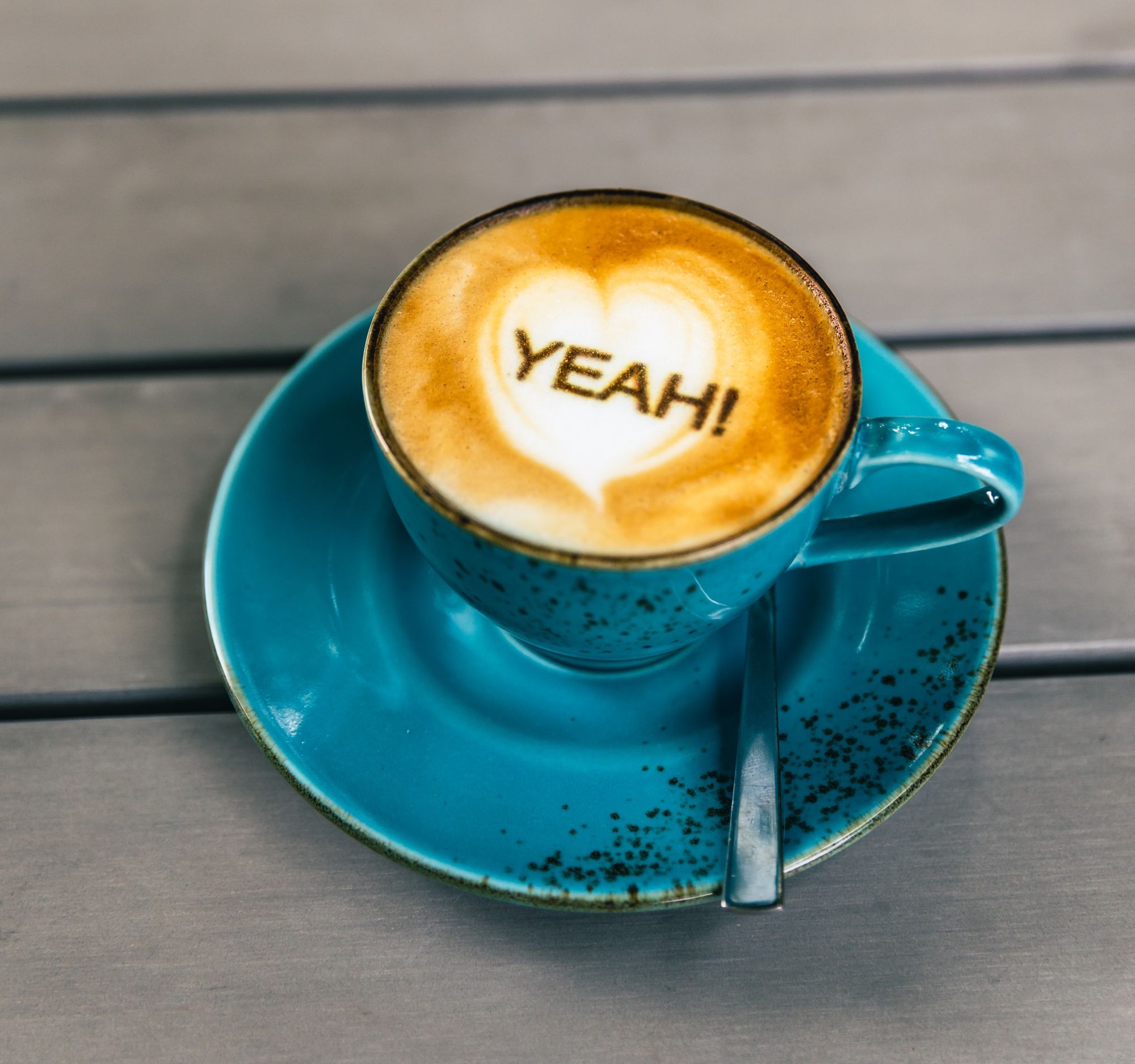 Coffee cup showing 'yeah' as a caption in the foam